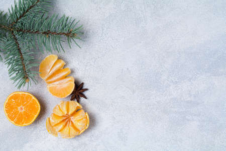 Winter composition with tangerines, spices, almonds and fir tree on blue background. Top view, copy space for textの写真素材