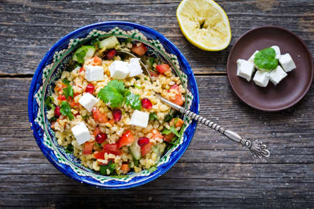 Bowl of healthy and delicious fresh tabbouleh salad with bulgur, pomegranate and feta cheeseの写真素材