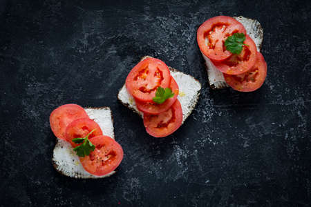 Healthy sandwhiches with fresh ricotta cheese, tomatoes and parsley on whole grain rye bread. Side...