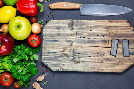 Fresh organic vegetables, wooden cutting board and chefs knife for healthy vegan cooking. Copy space...