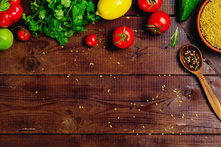 Fresh vegetables, spices and herbs on wooden background with space for text. Healthy ingredients for cooking. Top view.の写真素材