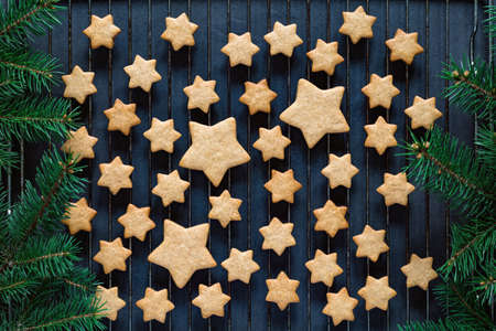 Stars shaped gingerbread cookies for Christmas on cooling rack. Holiday baking. Top view, toned imageの写真素材