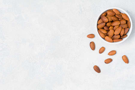 Almonds in bowl on bright background with copy space for textの写真素材