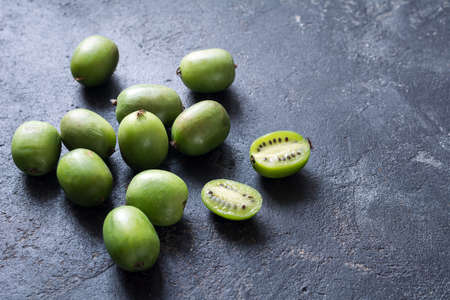 Baby kiwi or mini kiwi fruits on stone background. Closeup viewの写真素材