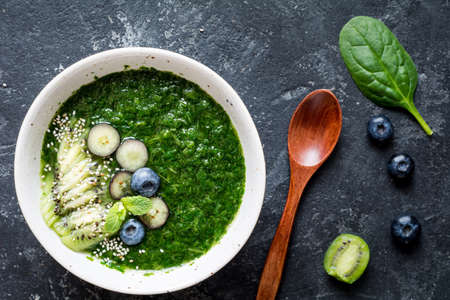 Detox green smoothie with spinach, kiwi, kale, blueberries and chia seeds in bowl. Top viewの写真素材