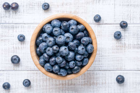 Bowl of fresh blueberries on vintage white background. Top viewの写真素材