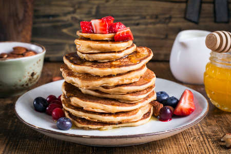 Healthy oat pancakes topped with fresh strawberries and honey. Closeup viewの写真素材
