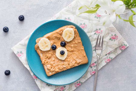 Teddy bear shaped peanut butter. Funny animal face toast for kids. Top view