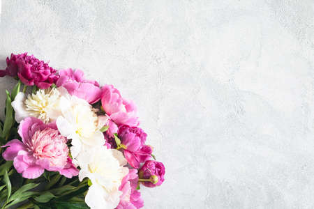 Peonies on white wooden planks background with copy space, top view. Great use as mock up for products, feminine design projects, wedding / invitation / holiday cards and so onの写真素材