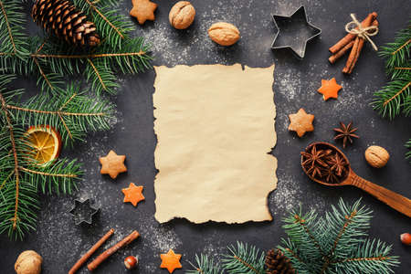Santa wishlist or Christmas letter background concept: holiday decorations, fir tree, spices, stars and cookie cutters with blank paper for text . Top view, horizontalの写真素材