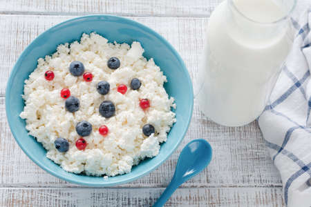 Cottage cheese with fresh berries and bottle of milk. Organic farmers dairy productsの写真素材