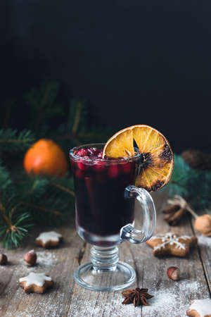 Mulled wine in glass with cranberries and spices decorated with burnt orange. Christmas drink. Holiday food conceptの写真素材