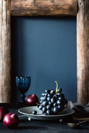 Black grapes on vintage silver tray still life. Vertical compositionの写真素材