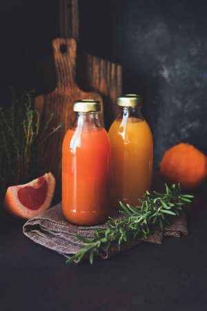 Fresh citrus juice in bottle. Grapefruit and orange fresh juice with pulp, healthy detox drink. Selective focus, toned imageの写真素材