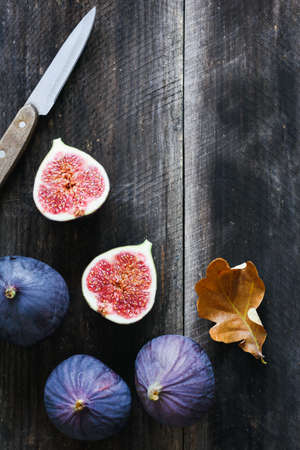 Fresh purple figs and table knife on old wooden background with copy space for text. Top viewの写真素材