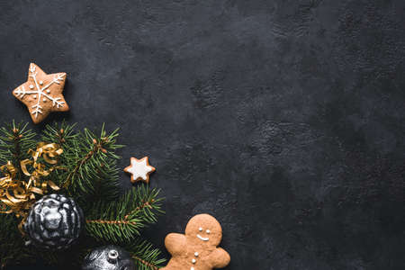 Christmas background. Gingerbread cookies, fir tree, christmas toys and holiday decorations frame on blackboard or stone backdrop. Top view with copy space for textの写真素材