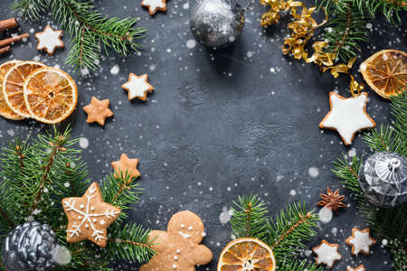Christmas frame with gingerbread cookies, fir tree, spices and dried orange rings. Top view with...