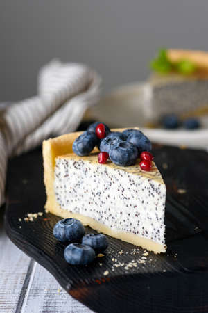 Slice of cake with poppy and blueberries. Closeup view, selective focus. Toned imageの写真素材