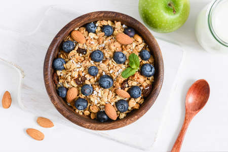 Granola, milk and green apple on old white table. Healthy breakfast food, healthy lifestyle, dieting and weight loss conceptの写真素材