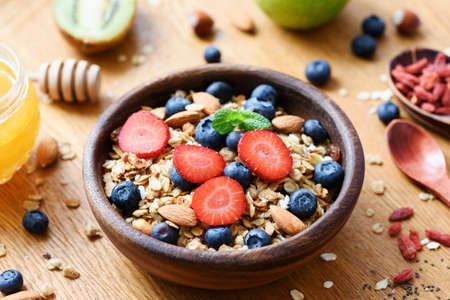 Granola bowl with fresh blueberry strawberry and nuts. Healthy lifestyle, healthy eating, dieting, balanced meal conceptの写真素材