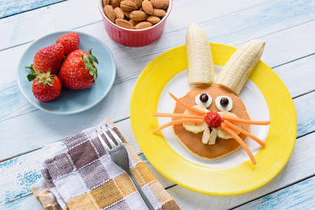 Colorful Easter breakfast for kids. Easter Bunny food art on yellow plate. Top viewの写真素材