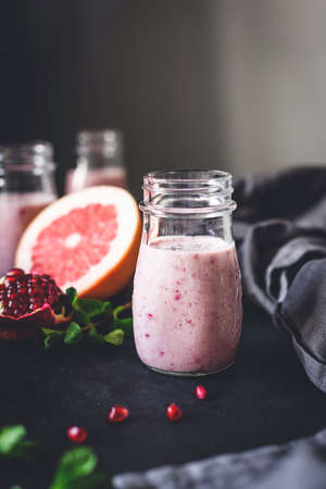 Pink berry smoothie with pomegranate, acai and grapefruit in jar. Toned, selective focus. Healthy lifestyle, fitness, detox, dieting, clean eating, vegan, vegetarian conceptの写真素材