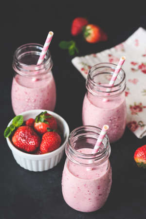 Strawberry raspberry smoothie in bottle jar with drinking straw, selective focus, toned image. Cleansing, vegan, vegetarian, summer, detox conceptの写真素材