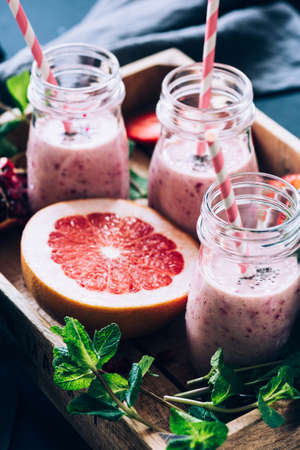 Pink grapefruit smoothie in bottles. Healthy detox drink. Toned image, selective focusの写真素材