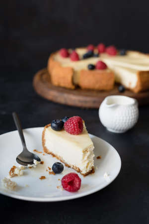 Slice of cheesecake with missing bite on white plate. selective focusの写真素材