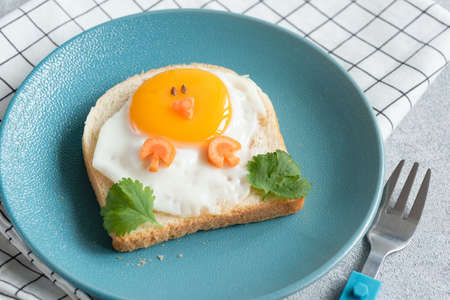 Funny chicken sandwich for kids on a blue plate. Food art, creative idea for children breakfast...