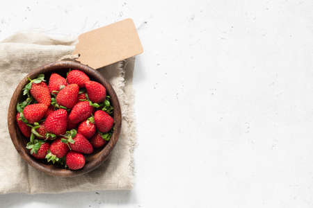 Strawberry in bowl. Fresh strawberries on white concrete background. Top view with copy space for textの写真素材