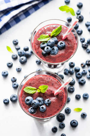 Blueberry acai smoothie in glass on white background. Superfood smoothie top view. Trendy fruit berry smoothieの写真素材