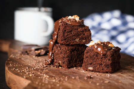 Brownies on wooden board. Homemade chocolate cake brownie squares. Closeup view, selective focus