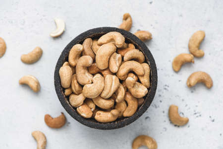 Cashews in bowl on concrete background, top view selective focusの写真素材
