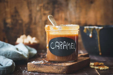 Caramel sauce in jar on woodenの写真素材