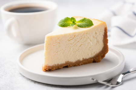 Tasty Plain New York Cheesecake On White Plate Decorated With Mint Leaf. Closeup View