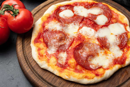 Tasty Italian Pizza With Salami Pepperoni Mozzarella Cheese On Wooden Pizza Boardの写真素材
