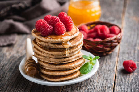 Pancakes with raspberries and honey on wooden table.の写真素材