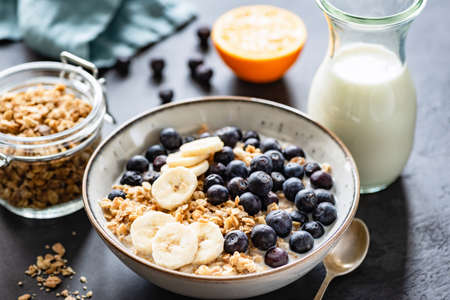 Granola, Fruits, Berries in bowl on black concrete background. Healthy breakfast cereals. Concept of dieting, healthy eating, clean eating