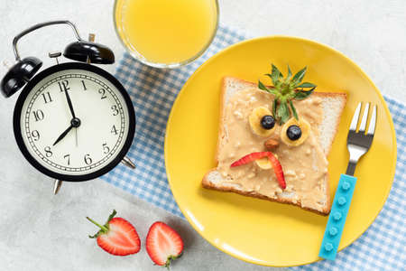 Kids breakfast meal, peanut butter toast with funny face of angry bird or angry pirate on a trendy...