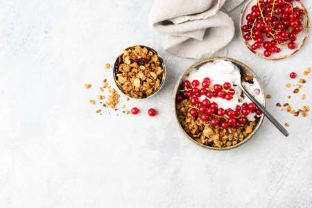 Oat granola with natural greek yogurt and red currant berries on grey cement wall.の写真素材
