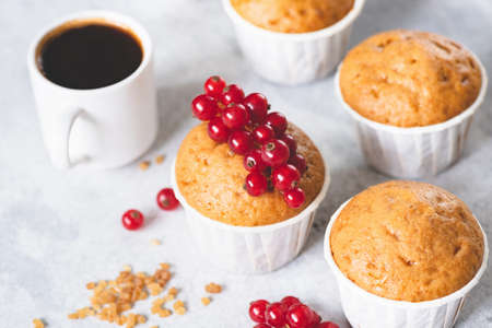 Homemade sweet vanilla muffins decorated with red berries and cup of black coffee espressoの写真素材