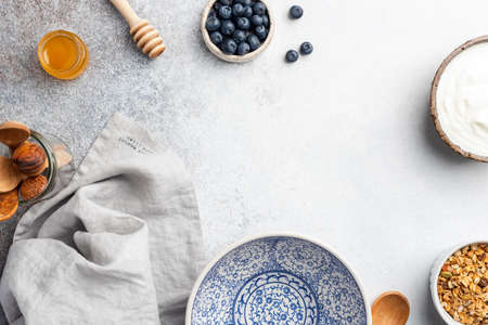Breakfast Table with empty plate, yogurt, granola and berries. Top view with copy space for textの写真素材