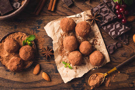 Homemade chocolate truffles with cocoa powder, spices and nuts.
