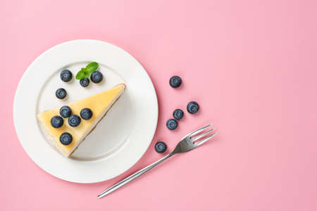 Cheesecake Slice On Plate With Blueberries, Top view, Pink Background. Trendy Fashion Dessert