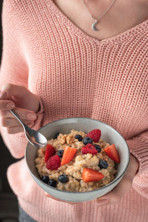 Woman Eating Oatmeal Porridge With Berries, Healthy Breakfast, Clean Eating, Dieting, Vegan Lifestyle Conceptの写真素材