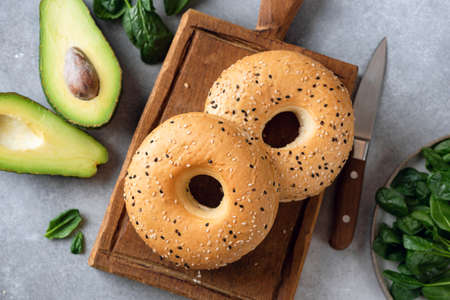 Fresh sesame bagels and avocado ready for making healthy vegan avocado sandwichの写真素材