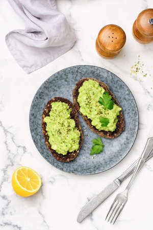 Rye bread toast with mashed avocado cream. Vegan avocado toast with hemp seedsの写真素材