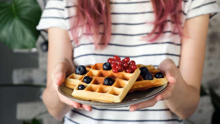 Plate of belgian waffles in female hands.の写真素材