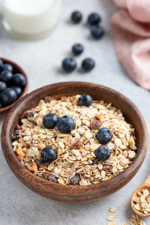 Bowl of oat muesli with nuts, dried fruit and blueberries. Healthy breakfast food, clean eating and...